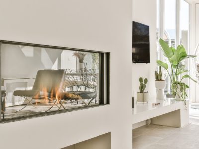 Contemporary fireplace with glass screen installed in white wall in living room at home