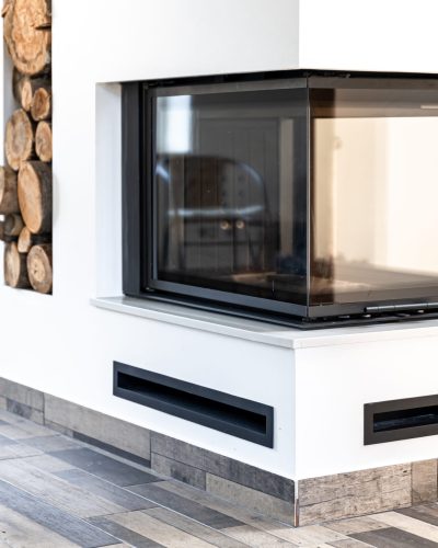 Modern home fireplace in the interior of the house. Living room corner style with fireplace decor and wood concept interior room style.