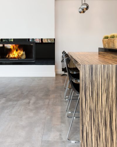 Modern living room in minimalist style, with fireplace and an eating bar with bar chairs