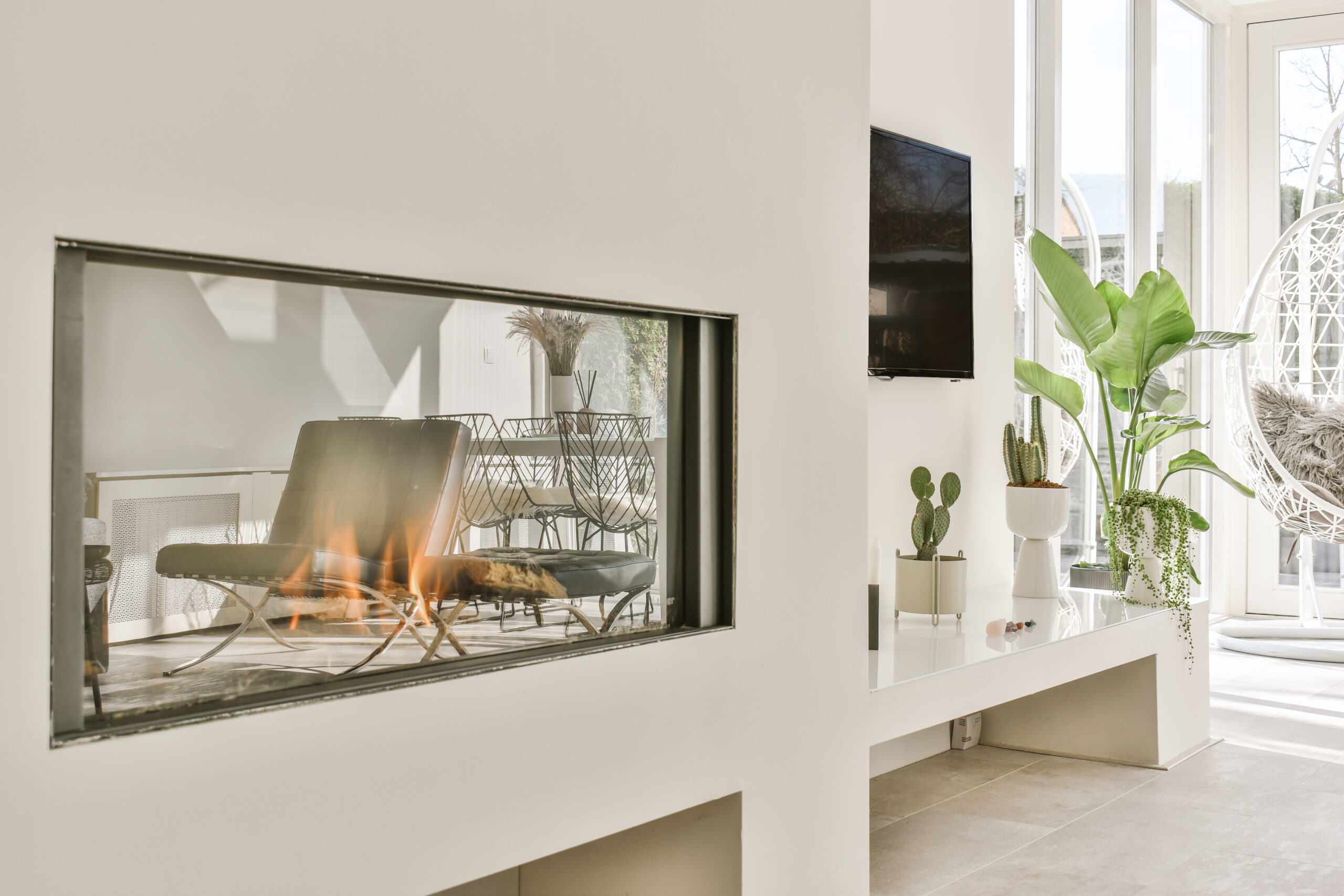 Contemporary fireplace with glass screen installed in white wall in living room at home