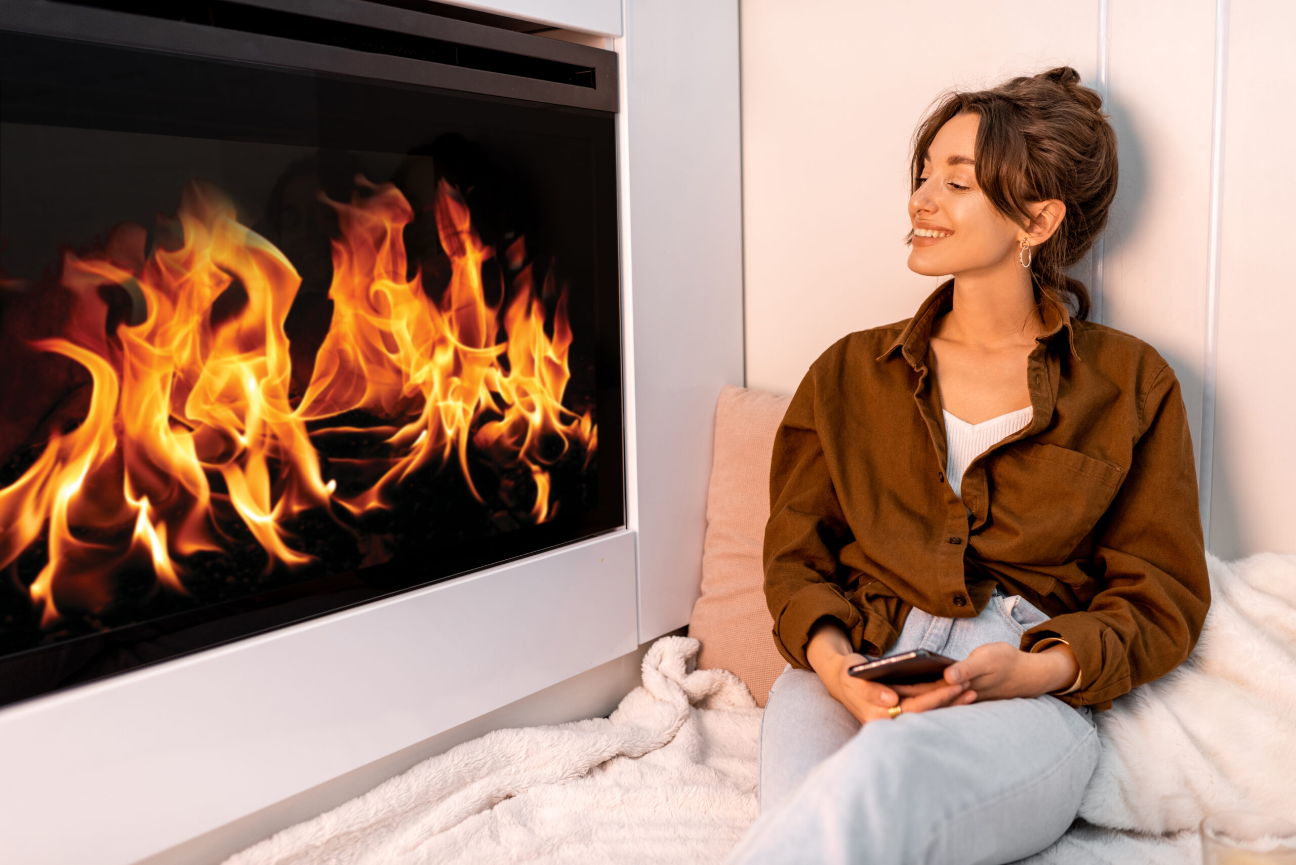 Young woman relaxing near the fireplace at the modern living room at home